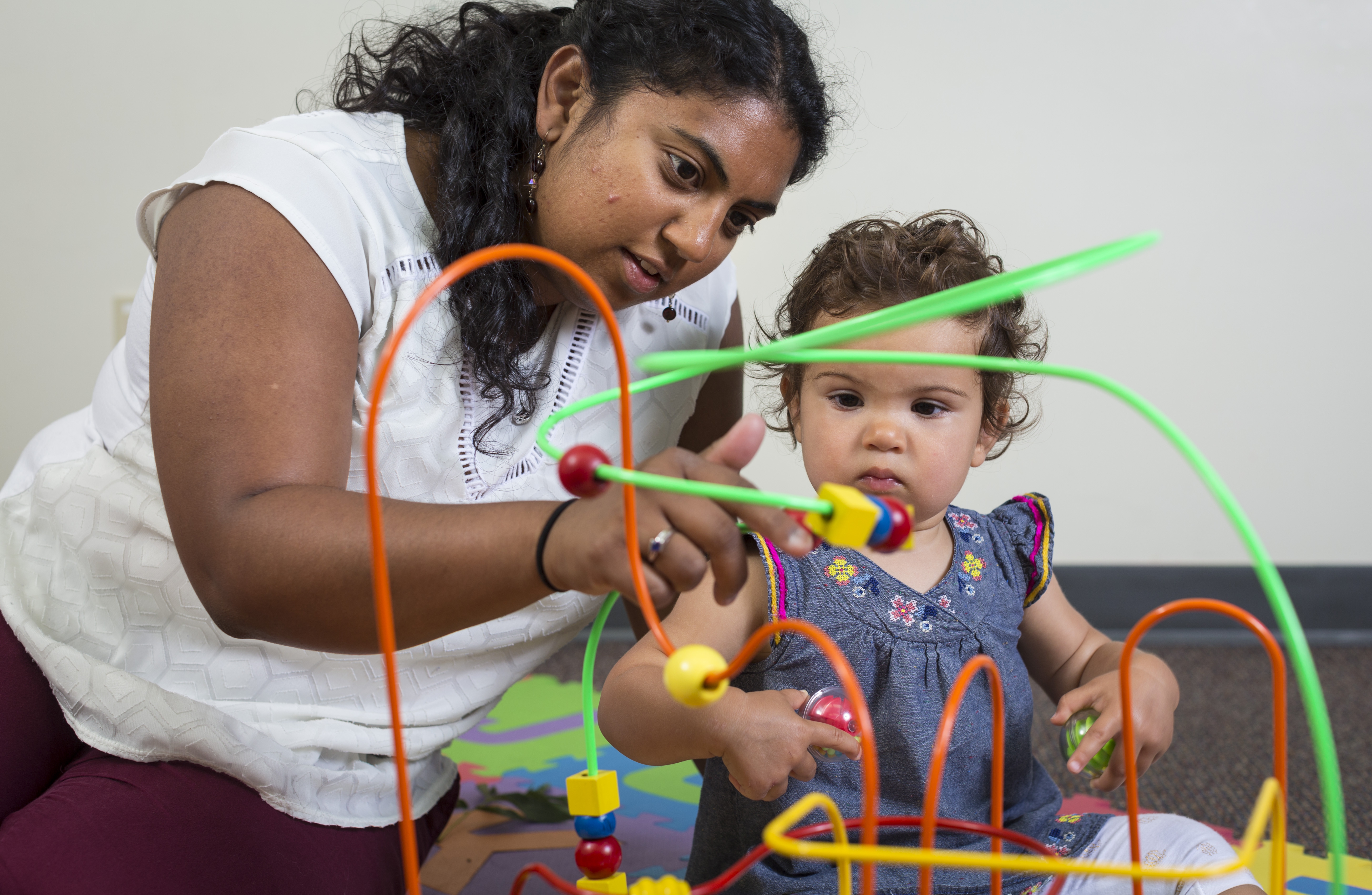 A mother and child play with toys in the lab.